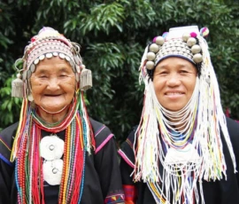 Learn about local traditions and the vibrant culture of the northern hill tribes. Two women from the Akha hill tribe wearing traditional colorful headdresses and ethnic attire.