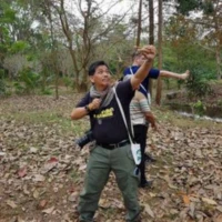 Day 1: A local guide shows how to launch seed bombs into the forest – a hands-on conservation activity inspired by the late King Bhumibol's reforestation philosophy at Baan Tum Sue. Local guide demonstrating seed bomb throwing activity at Baan Tum Sue homestay community conservation Thailand